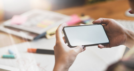 Designer hand's searching for new ideas with blank screen smartphone