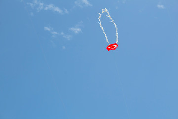 Kite floating in the blue sky with tasseled tail