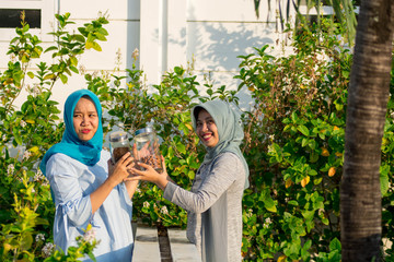 portrait of Two beautiful hijab  women shared coffee and almonds together in front of their coffee...