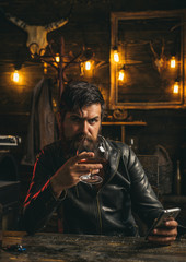 Man drinks brandy or whiskey. Bearded man wearing suit and drinking whiskey brandy or cognac. Sommelier tastes alcohol drink. Drinking and party concept. Degustation and tasting.