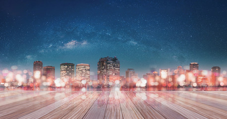 Panoramic Osaka city at night with glowing Bokeh light with starry sky and empty building terrace