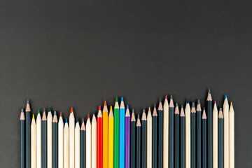 black, white and lgbt color pencils on black paper background. Mock up, copy space. concept of...