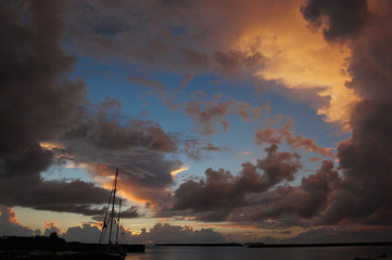 朝日にも夕日にも見える空とシルエットの港