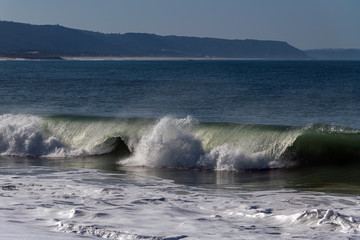 Naklejka premium Foamy Atlantic waves next to Nazare, Portugal.