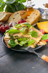 Omelette with vegetables, cheese and spinach leaves on toast with ice salad. Tasty breakfast. Vertical shot