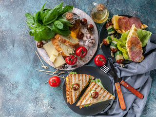 Toasts with scrambled eggs and smoked beef, vegetables and cheese. Tomatoes and spices. Delicious breakfast or snack. Top view