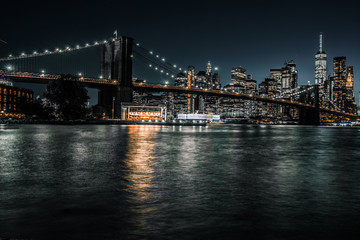 Fototapeta na wymiar Waterfront Brooklyn with iconic Brooklyn Bridge and downtown Manhattan during the evening