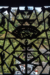 Black iron grill with forged pattern on window