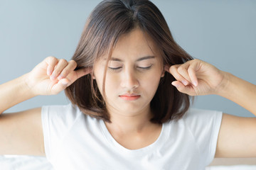 Fototapeta premium Closeup woman covering ears with her hand, noise problem, selective focus