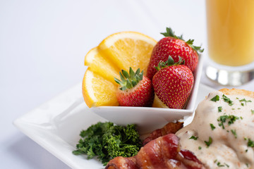 Strawberries and oranges in a square white bowl 