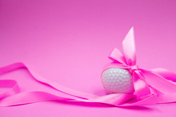 golf ball with pink ribbon are on pink background.