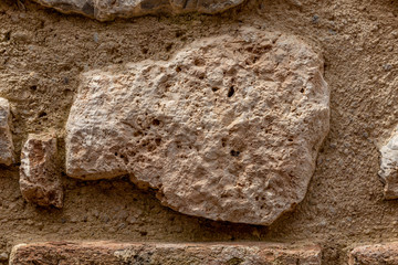 The texture of the surface of natural stone, close-up. Building material of ancient civilizations. Background. Spaces for text.