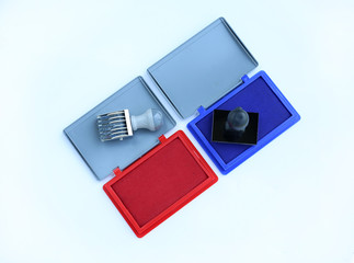 Rubber stamper and Red - Blue Ink cartridges on white background.