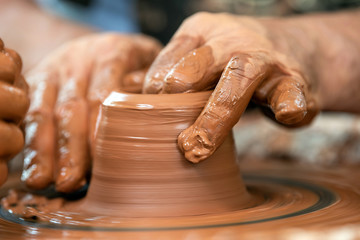 Potter makes pottery dishes on potter's wheel