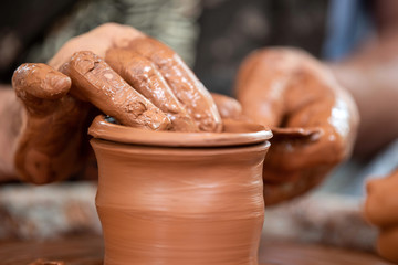 Potter makes pottery dishes on potter's wheel