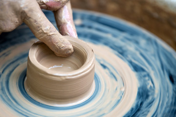 Potter makes pottery dishes on potter's wheel