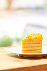 Orange cake with orange topping  on wooden table in coffee cafe