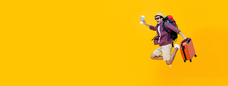 Young Asian man tourist jumping with luggage