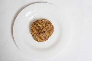 Meat roast cutlet on a white plate on a white background.