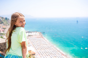 Young girl in background of mediterranean sea and sky.