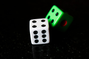 Two dice on a black background, game play