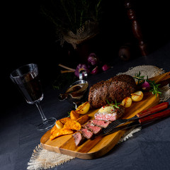 rustic medium butter beef steak with herbs and potato wedges