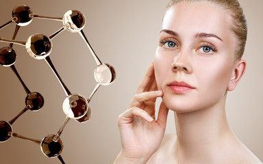 Beautiful young woman near beige glass molecules.