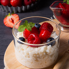 delicious milk rice with different berries and red fruit jelly
