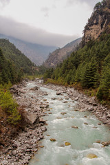 Dudh Koshi snow river (Dudh Kosi river or Milk-Koshi River) flows in mountain valley near Phakding village in Himalayas in Nepal. Nature, Lakes and Rivers, Mountains, Travel and Tourism concept. - obrazy, fototapety, plakaty