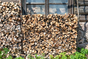 Background of dry chopped firewood logs in a pile. Preparation for the winter season, fossil fuels