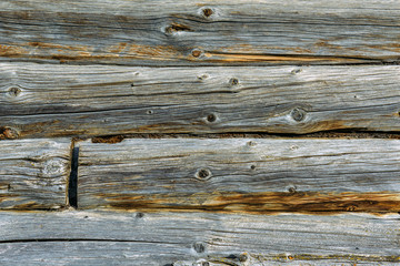 Old wooden background with horizontal boards, grey wooden wall of a dilapidated village house, close up.