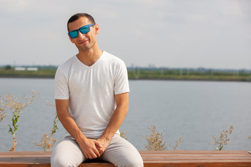 Smiling bearded young man showing thumbs up. Cheerful handsome young man gesturing outdoor.