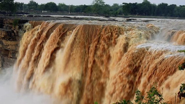 Chitrakoot waterfall swollen and silt filled after monsoon rains in India. Popular tourist location with scenic landscape views of the Niagara Falls of India.