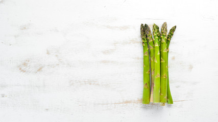 Fresh green asparagus on a white wooden background. Healthy food. Top view. Free space for your text.