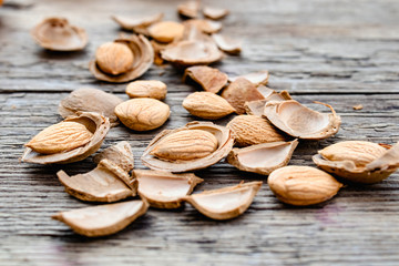The core of apricots and stones on the background of old boards. Apricot pits for the manufacture...
