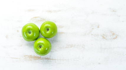 Green apples on a white wooden background. Fruits. Top view. Free space for text.