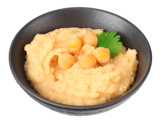 black bowl with chickpea hummus isolated on white background
