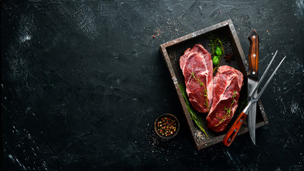 Raw Steak Ribeye. On a black stone table. Top view. Free space for your text.