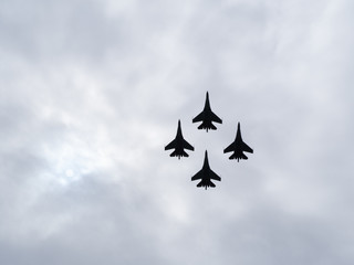  four military fighter jets silhouettes isolated on sky  with copy space. Attack airplanes. Empty space for text. su-27 airshow