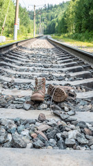 Old boots stand on the railroad. difficult road