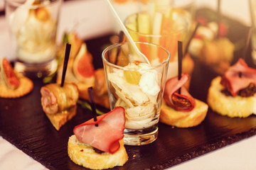 Little glasses with fresh salads stand on white table
