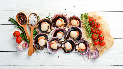 Fototapeta na wymiar Scallops with Ingredients. Seafood. Top view. On a white wooden background. Free copy space.