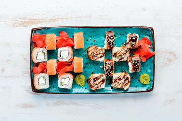 Sushi and maki rolls on a plate. Top view. Free space for your text. On a white background.