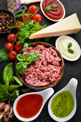 Ingredients for cooking sauce Bolognese. On a black background. Top view. Free space for your text.