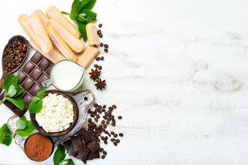 Ingredients for dessert tiramisu on a white wooden background.