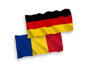 National vector fabric wave flags of Germany and Romania isolated on white background. 1 to 2 proportion.