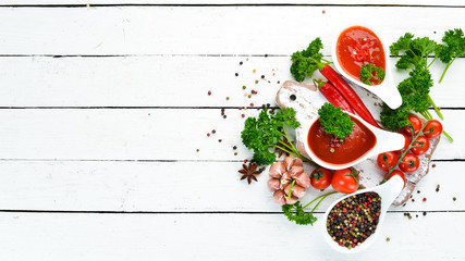 Ketchup, barbecue sauce, tomato sauce. A set of tomato sauces on a white wooden background. Top view. Free space for your text.