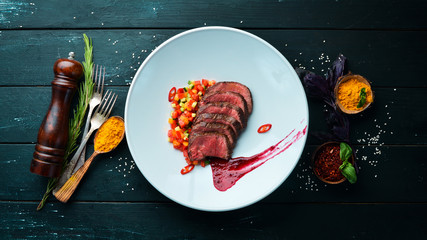Veal baked with vegetables. In the plate. Top view. Free space for your text.