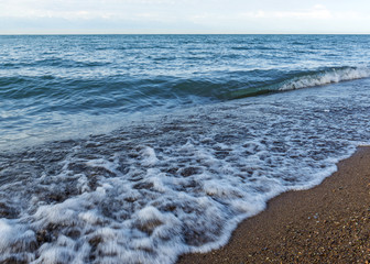 .Wild beach lake. The coastline of the sea. Brown sand and blue sky. Mountain View. Rest on the coast.