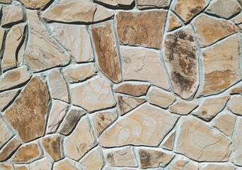 Imitation of a wild stone. Wall decorated with ocher stone tiles. The effect of the fortress. Close...